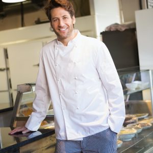 smiling-baker-leaning-on-counter-at-the-bakery.jpg